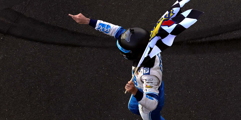 Austin Cindric celebrates with the checkered flag at the Brickyard