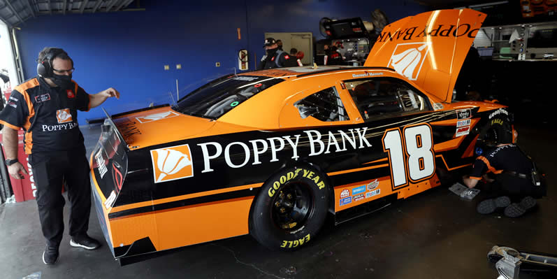 Crew member work on the #18 Poppy Bank Toyota at Daytona International Speedway