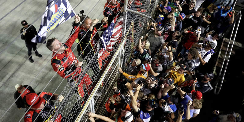 Justin Allgaier and crew climb the fence