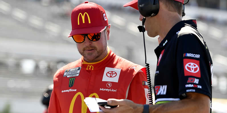 Kurt Busch works with a crew member during qualifying